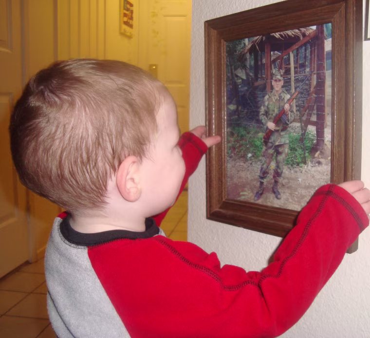 CJ Duhachek looks at a photo of his father, Staff Sergeant Chamous Duhachek, who is currently deployed in Afghanistan.